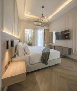Schlafzimmer mit einem großen weißen Bett und einem Schreibtisch in der Unterkunft Basilica Hotel in Santa Marta