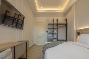 a bedroom with a large white bed and a desk at Basilica Hotel in Santa Marta