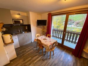 a kitchen with a table and a table and a window at Studio Châtel, 1 pièce, 4 personnes - FR-1-693-104 in Châtel