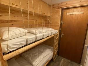 two bunk beds in a wooden room with a door at Studio Châtel, 1 pièce, 4 personnes - FR-1-693-104 in Châtel