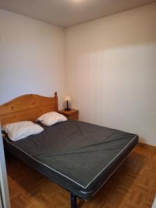 a bedroom with a large bed with two pillows at Appartement dans un chalet, résidence avec piscine in La Toussuire