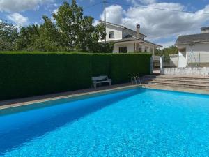 a large blue swimming pool in front of a house at Casa Vilachá - Ribeira Sacra in Puebla del Brollón