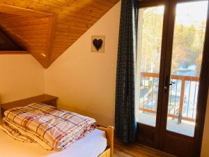 um quarto com uma cama, uma janela e uma porta em Les Ribambelles em Puy-Saint-Vincent