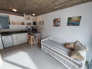 何塞伊格納西奧的住宿－Mar, Bosque y Lago，一间带一张床的房间和一间带柜台的厨房