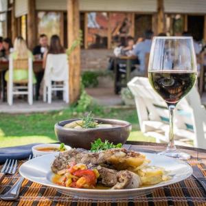 a plate of food and a glass of wine on a table at Finca La Valletana in Vista Flores