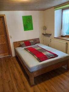 ein großes Bett in einem Zimmer mit Holzboden in der Unterkunft Ferienwohnung Luzia in Eichstegen