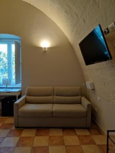 sala de estar con sofá y TV de pantalla plana en Tenuta Danesi & Bubble Rooms, en Matera