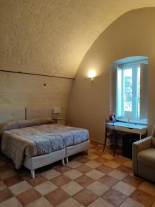 1 dormitorio con cama, escritorio y ventana en Tenuta Danesi & Bubble Rooms en Matera