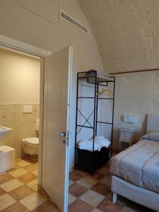 a bedroom with a bed and a bathroom with a toilet at Tenuta Danesi & Bubble Rooms in Matera