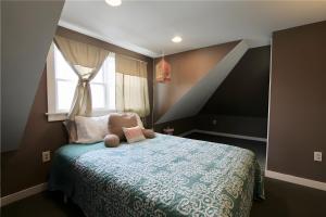 sypialnia z łóżkiem z niebieską kołdrą i oknem w obiekcie Apartment 4bdr 2-3 floor, waterview, walk to beach w mieście Middletown