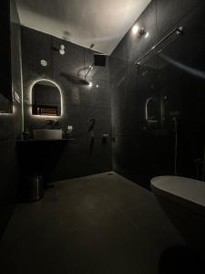 a dark bathroom with a sink and a toilet at Karvaan B&B - 2bhk Homestay in Pālampur