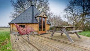 une petite cabine avec une table de pique-nique et un banc dans l'établissement KOTA, à Daumeray