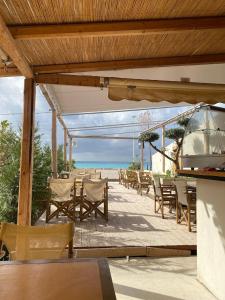 un patio con mesa, sillas y el océano en Tonea's Houses en Himare