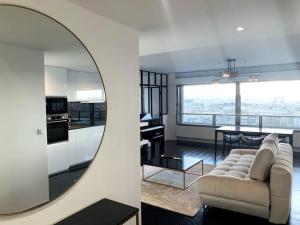 a living room with a couch and a kitchen with a mirror at RARE 75m2 Parisian apartment, breathtaking views! in Paris