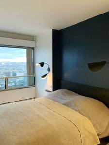 a bedroom with a bed and a large window at RARE 75m2 Parisian apartment, breathtaking views! in Paris