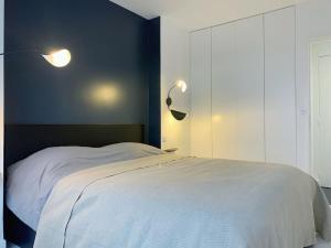 sypialnia z białym łóżkiem i niebieską ścianą w obiekcie RARE 75m2 Parisian apartment, breathtaking views! w Paryżu