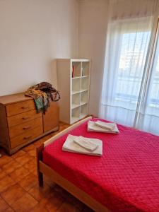 a bedroom with a bed and a dresser with two towels at DOMUS DIVI - Eur Torrino in Rome