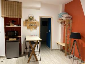 Habitación pequeña con mesa y cocina en La petite Escapade, en Calais