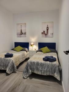 una camera con due letti e un comodino con due lampade di Casa Roma a Granada