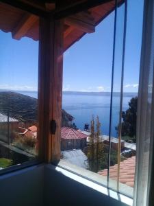 a view of the ocean from a window at Hostal Quilla Wasi Isla del Sol in Comunidad Yumani