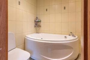 bagno con vasca bianca e servizi igienici di HermiinStay - apartment with sauna and hot tub a Tartu