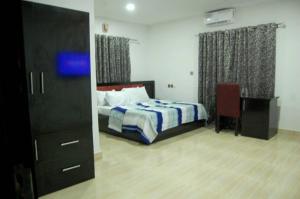 a bedroom with a bed and a dresser and a chair at STARSAPPHIRE LUXURY HOTELS LTD 