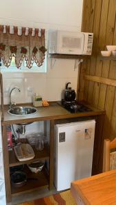 a small kitchen with a sink and a microwave at Cabanas MORIÁ in Garopaba