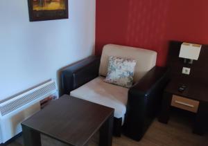 een kleine kamer met een stoel en een tafel bij Igzila apartment in Banya