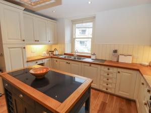 a kitchen with white cabinets and a bowl on a counter at Ings House in Hawes