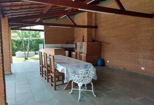 a patio with a table and chairs and a kitchen at Chácara em Indaiatuba in Indaiatuba