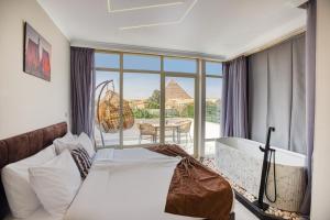 a bedroom with a bed and a view of the pyramids at Tree Lounge Pyramids View INN , Sphinx Giza in Cairo