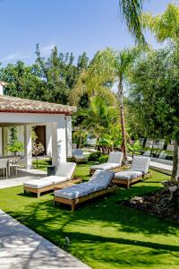 a patio with chaise lounges on the grass at Villa JAP in Benidorm