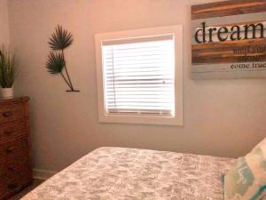 a bedroom with a bed and a window and a dresser at In the Heart of Downtown Dunedin One Bedroom Apt NO KIDS, NO PETS in Dunedin