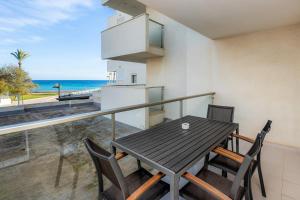 balcón con mesa, sillas y vistas al océano en Apartamento Olga, en Cala Millor