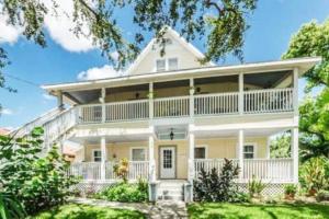 an exterior view of a large white house at In the Heart of Downtown Dunedin One Bedroom Apt NO KIDS, NO PETS in Dunedin