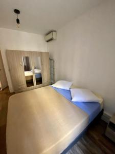 a bedroom with a large bed with blue sheets and white pillows at Appartement centre-ville in Bastia