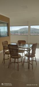 een eetkamer met een glazen tafel en 4 stoelen bij HOTEL LUCIANA in Serrinha