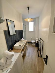 uma casa de banho com um lavatório branco e um WC. em Appartement centre-ville em Bastia