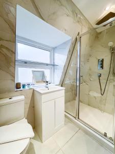 uma casa de banho com um chuveiro, um WC e um lavatório. em Large and very stylish apartment em Londres