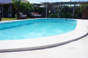 a large swimming pool with blue water in a yard at João Jungle in Açafora