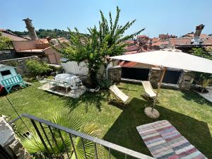 einen kleinen Garten mit Stühlen und einem Sonnenschirm in der Unterkunft Villa St. Georges in Piran