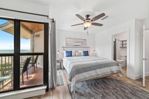 a bedroom with a bed with a ceiling fan and a balcony at Gulfside Townhomes 9 in Gulf Shores +37 photos