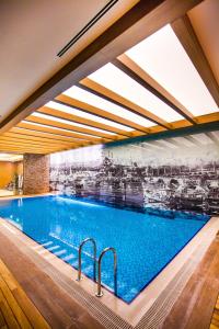 a large swimming pool in a building with a ceiling at Gorrion Hotel Istanbul in Istanbul
