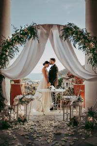 une mariée et un marié embrassant sous une arche de mariage dans l'établissement Villa Gelsomino Exclusive House, à Santa Margherita Ligure