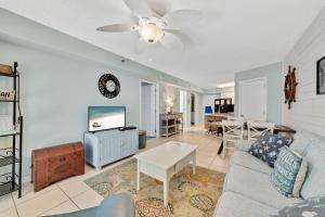 ein Wohnzimmer mit einem Sofa und einem TV in der Unterkunft Harbour Place 104 in Gulf Shores