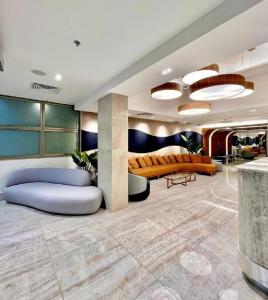 eine Lobby mit Sofas und Tischen in einem Gebäude in der Unterkunft Hotel Astoria Palace in Rio de Janeiro