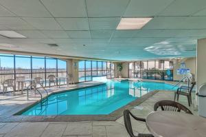 ein großer Pool mit Stühlen und einem Tisch in einem Gebäude in der Unterkunft Harbour Place 104 in Gulf Shores