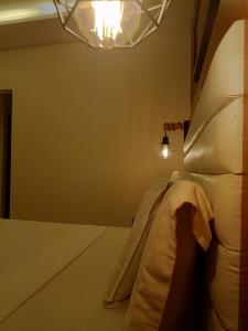 - une chambre avec un lit et une lumière sur le mur dans l'établissement First International Inn Downtown, à Limbe