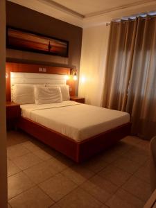 a bedroom with a large bed in a room at First International Inn Downtown in Limbe