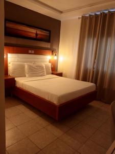 a bedroom with a large bed in a room at First International Inn Downtown in Limbe +11 photos
